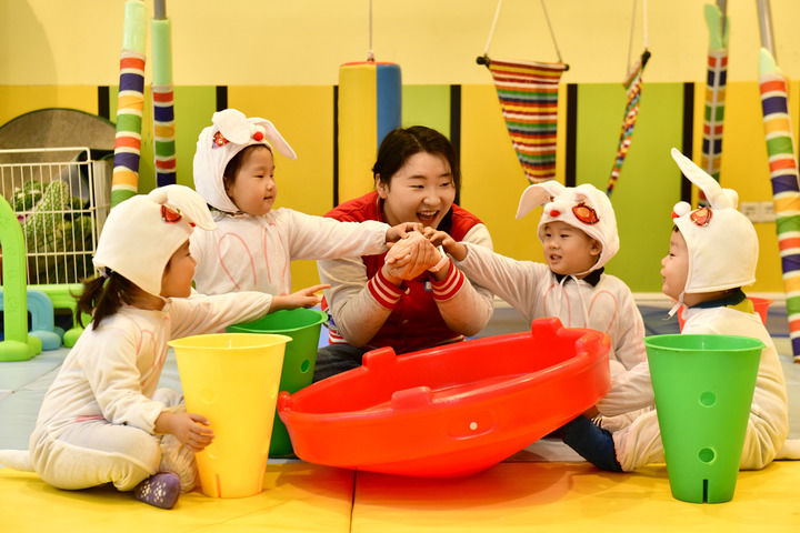 2025年2月20日,在山東省日照市東港區知子樹托幼園,老師陪伴孩子做游戲。新華社記者 郭緒雷 攝